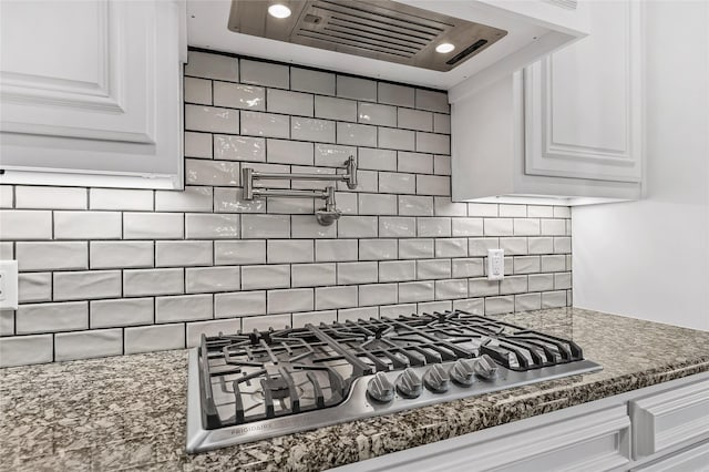 2604 Silverado Trl, Sherman, TX 75092 - kitchen view of stainless steel gas cooktop, ventilation hood, pot filler, white cabinets, and backsplash
