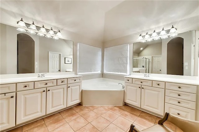 946 Briar Oaks Dr, Rockwall, TX 75087 - bathroom featuring tile patterned floors, two vanities, a bath, a stall shower, and vaulted ceiling