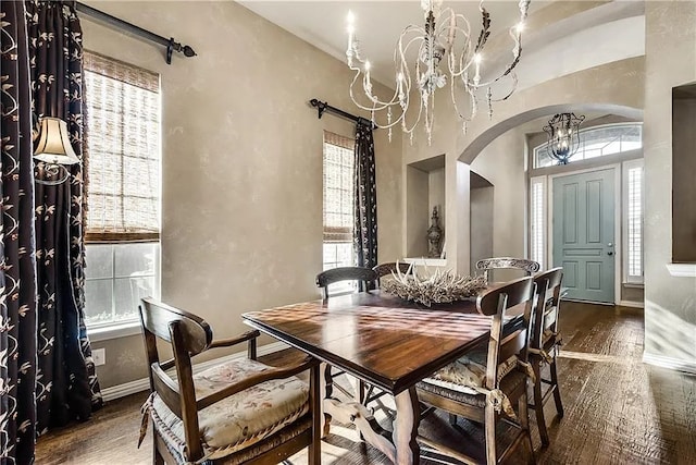 946 Briar Oaks Dr, Rockwall, TX 75087 - dining room with arched walkways, a chandelier, wood finished floors, healthy amount of natural light, and a high ceiling