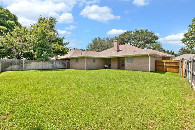 3937 Marsh Ln, Fort Worth, TX 76123 - back of house with a chimney, a fenced backyard, and brick siding
