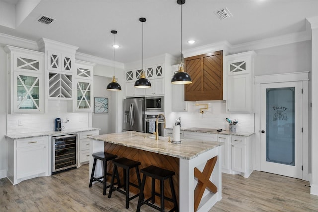 12457 Maplewood Dr, Lindale, TX 75771 - kitchen with wine cooler, appliances with stainless steel finishes, backsplash, light wood-type flooring, and ornamental molding