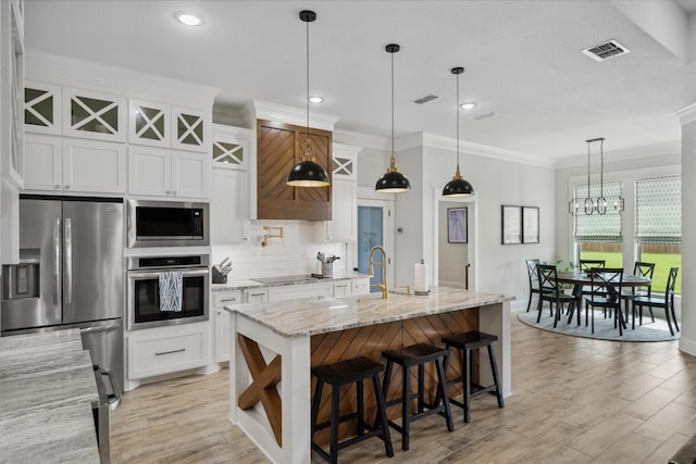 12457 Maplewood Dr, Lindale, TX 75771 - kitchen with stainless steel appliances, tasteful backsplash, white cabinets, light wood finished floors, and ornamental molding