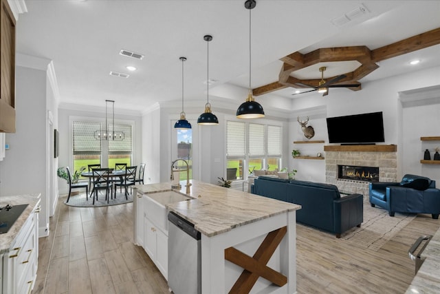 12457 Maplewood Dr, Lindale, TX 75771 - kitchen with stainless steel dishwasher, a stone fireplace, white cabinets, plenty of natural light, and ornamental molding