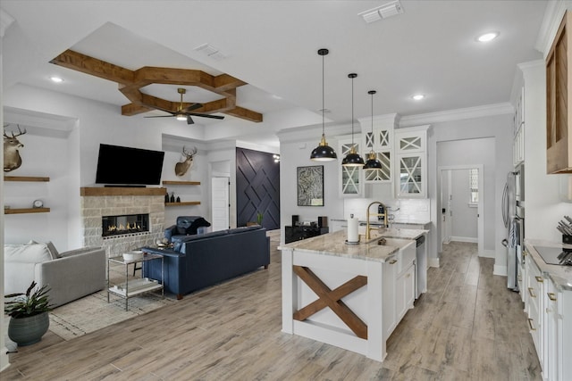 12457 Maplewood Dr, Lindale, TX 75771 - kitchen with a stone fireplace, a ceiling fan, white cabinetry, stainless steel appliances, and open floor plan