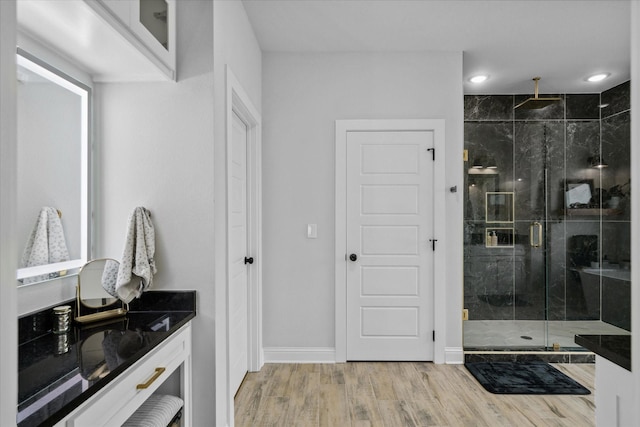 12457 Maplewood Dr, Lindale, TX 75771 - bathroom with a marble finish shower, wood finished floors, vanity, and recessed lighting