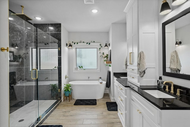 12457 Maplewood Dr, Lindale, TX 75771 - full bathroom with a stall shower, vanity, a soaking tub, wood finished floors, and recessed lighting