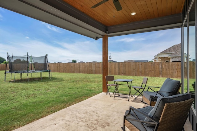 12457 Maplewood Dr, Lindale, TX 75771 - fenced backyard featuring a trampoline, a patio area, and ceiling fan