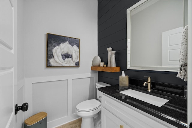 12457 Maplewood Dr, Lindale, TX 75771 - half bath featuring vanity, a decorative wall, wainscoting, and wood finished floors