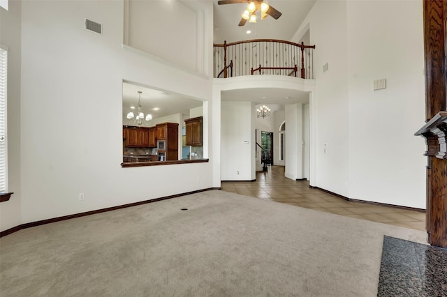 1910 Saint Johns Ave, Allen, TX 75002 - unfurnished living room featuring a chandelier, carpet, ceiling fan, tile patterned flooring, and a towering ceiling
