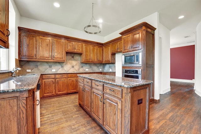 1910 Saint Johns Ave, Allen, TX 75002 - kitchen with stainless steel appliances, brown cabinetry, dark stone countertops, and recessed lighting