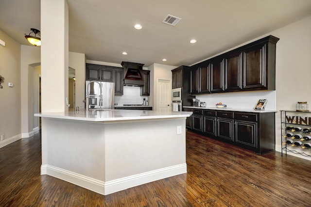 7219 Brisa Rd, Grand Prairie, TX 75054 - kitchen featuring stainless steel appliances, custom range hood, light countertops, dark wood-style floors, and recessed lighting