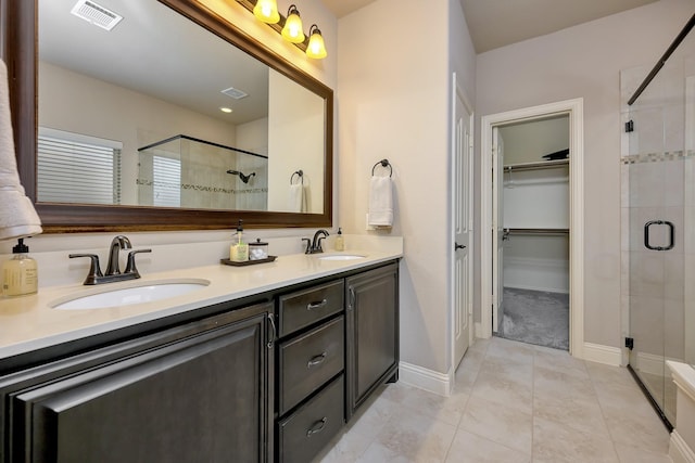 7219 Brisa Rd, Grand Prairie, TX 75054 - bathroom with a shower stall, a walk in closet, double vanity, and tile patterned flooring