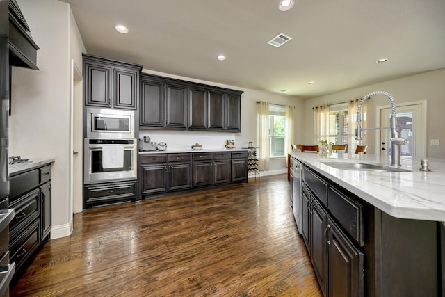 7219 Brisa Rd, Grand Prairie, TX 75054 - kitchen with stainless steel appliances, dark wood-style flooring, recessed lighting, a large island, and light stone counters