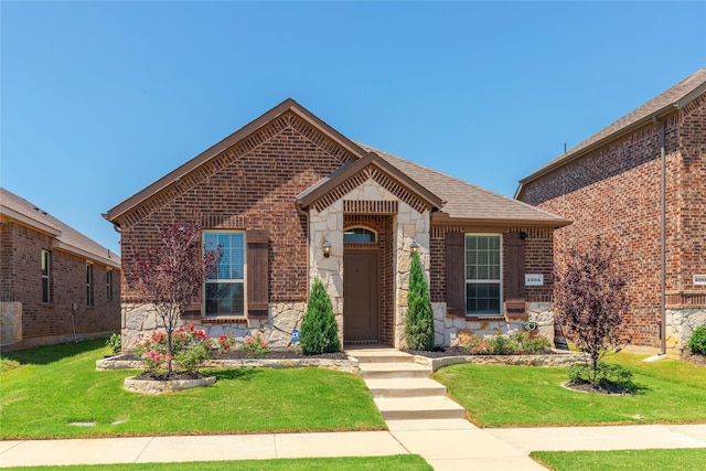 2265 Obsidian Dr, Little Elm, TX 76227 - view of front facade featuring stone siding, a front yard, brick siding, and roof with shingles