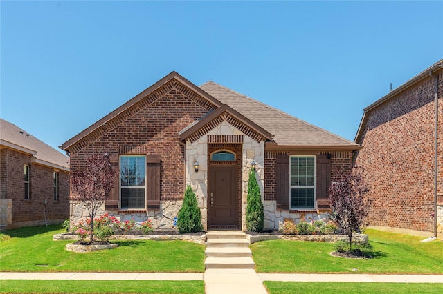 2265 Obsidian Dr, Little Elm, TX 76227 - view of front of house featuring stone siding, a front yard, roof with shingles, and brick siding