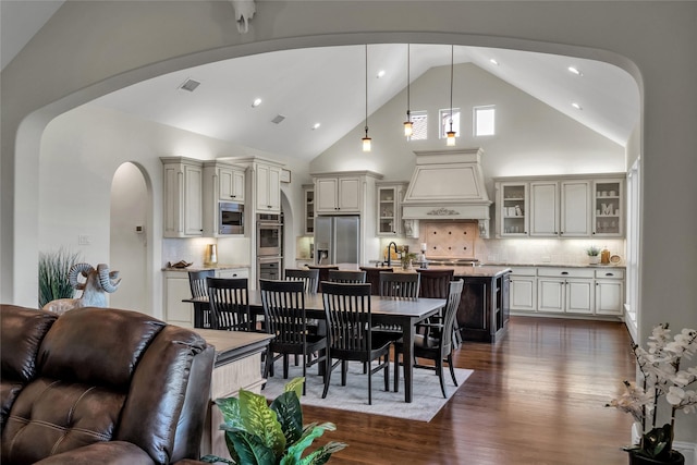 1400 Lakeside Dr, Prosper, TX 75078 - dining area with arched walkways, dark wood-style floors, high vaulted ceiling, and recessed lighting