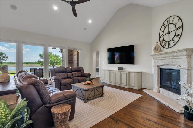 1400 Lakeside Dr, Prosper, TX 75078 - living room with a ceiling fan, high vaulted ceiling, arched walkways, dark wood-type flooring, and a high end fireplace