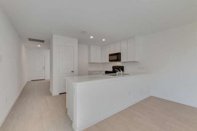 1657 Crested Way, Fort Worth, TX 76140 - kitchen with black appliances, light wood-type flooring, a peninsula, light countertops, and recessed lighting