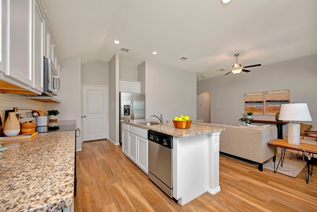 5361 Brentlawn Dr, Fort Worth, TX 76179 - kitchen with stainless steel appliances, light wood-style floors, a ceiling fan, white cabinets, and arched walkways