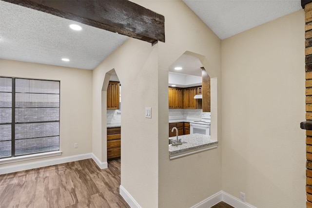 1037 Alicia Ln, Lancaster, TX 75134 - kitchen with arched walkways, white electric range oven, wood finished floors, decorative backsplash, and recessed lighting