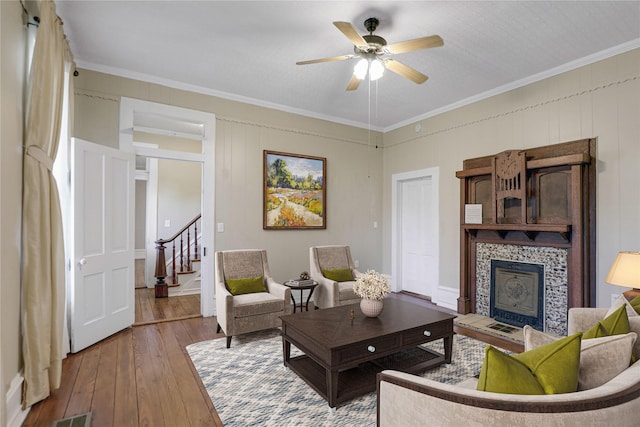 401 N Benge, Mckinney, TX 75069 - living area featuring hardwood / wood-style flooring, a tile fireplace, stairway, crown molding, and a ceiling fan