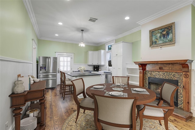 401 N Benge, Mckinney, TX 75069 - dining room with wood finished floors, ornamental molding, a fireplace, and recessed lighting