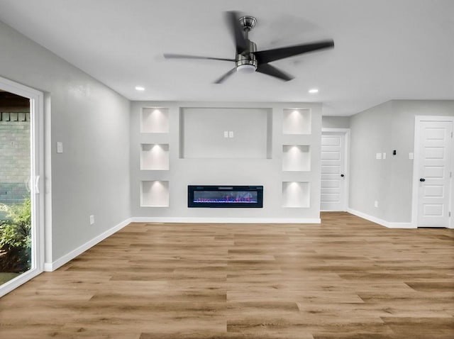 3505 Morningstar Ln, Farmers Branch, TX 75234 - unfurnished living room featuring wood finished floors, a ceiling fan, recessed lighting, a glass covered fireplace, and built in shelves