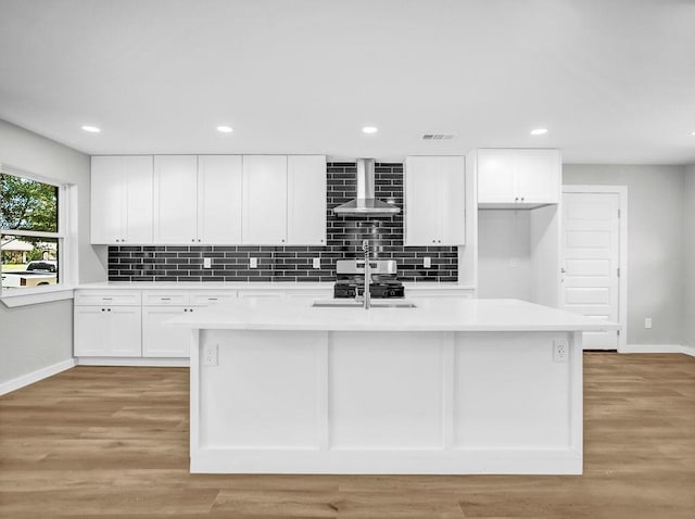 3505 Morningstar Ln, Farmers Branch, TX 75234 - kitchen featuring wall chimney exhaust hood, an island with sink, decorative backsplash, light countertops, and white cabinets