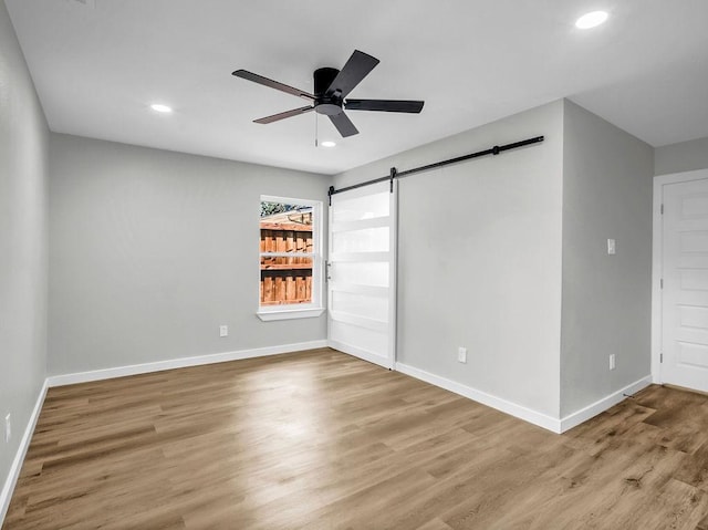 3505 Morningstar Ln, Farmers Branch, TX 75234 - unfurnished bedroom with a barn door, wood finished floors, recessed lighting, and ceiling fan