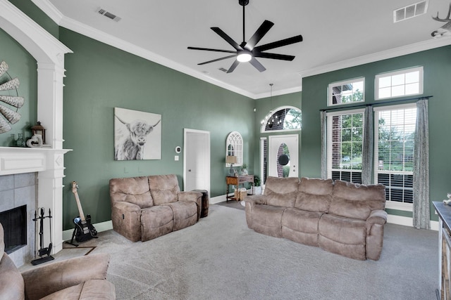 5631 Mission Ct, Midlothian, TX 76065 - carpeted living area with crown molding, a ceiling fan, healthy amount of natural light, a tiled fireplace, and a high ceiling