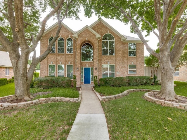6505 Tamarron Ln, Plano, TX 75024 - traditional-style house featuring a front lawn and brick siding