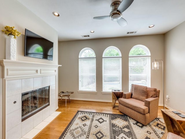 6505 Tamarron Ln, Plano, TX 75024 - living room with healthy amount of natural light, a tiled fireplace, a ceiling fan, light wood-type flooring, and recessed lighting
