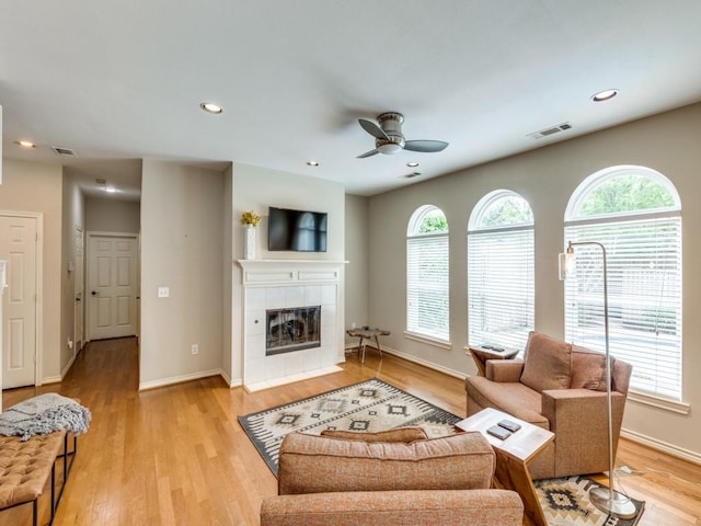 6505 Tamarron Ln, Plano, TX 75024 - living room with a ceiling fan, a tiled fireplace, light wood-style floors, and recessed lighting