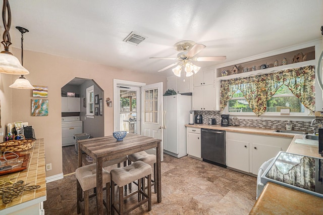 504 Harrison Ln, Hurst, TX 76053 - kitchen with dishwasher, healthy amount of natural light, white cabinets, and a ceiling fan