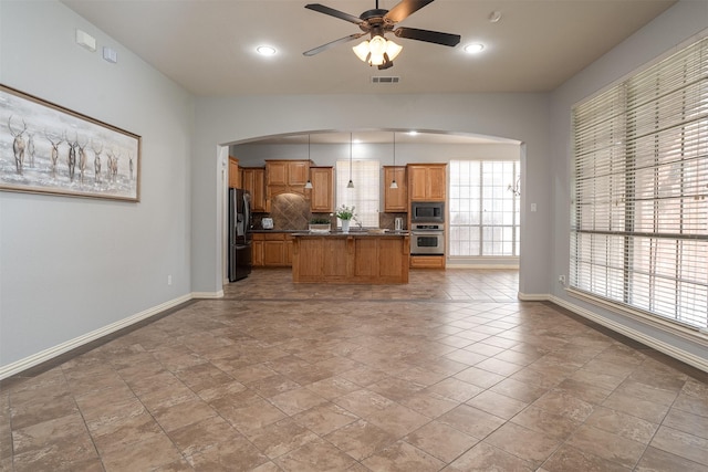 4748 Mcbreyer Pl, Fort Worth, TX 76244 - kitchen with appliances with stainless steel finishes, arched walkways, ceiling fan, open floor plan, and dark countertops