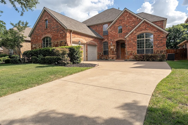 4748 Mcbreyer Pl, Fort Worth, TX 76244 - view of front facade featuring brick siding, roof with shingles, driveway, a garage, and stone siding