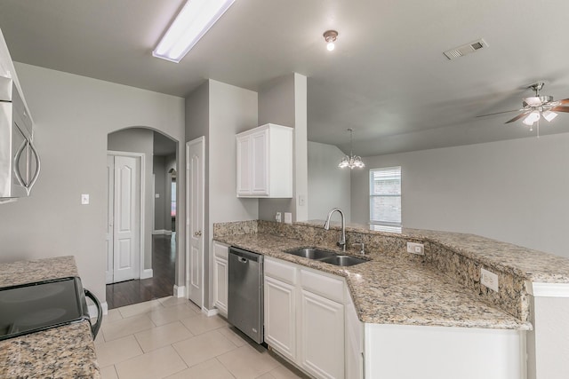 1102 David Dr, Euless, TX 76040 - kitchen with appliances with stainless steel finishes, a ceiling fan, a peninsula, arched walkways, and white cabinets