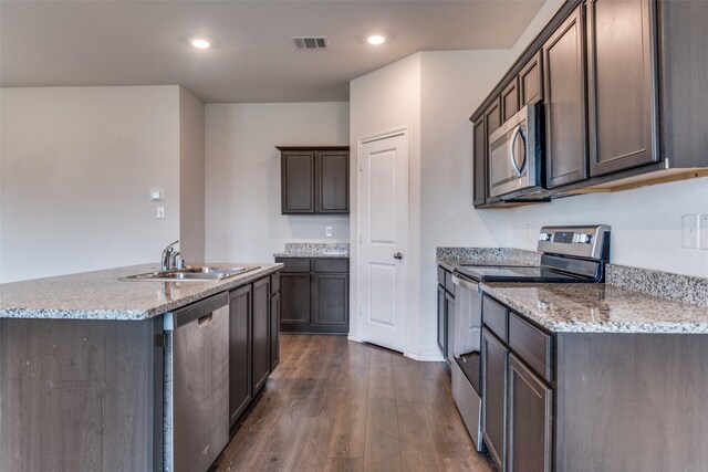 1653 Seadrift Dr, Forney, TX 75126 - kitchen featuring appliances with stainless steel finishes, dark wood-type flooring, a kitchen island with sink, dark brown cabinetry, and recessed lighting