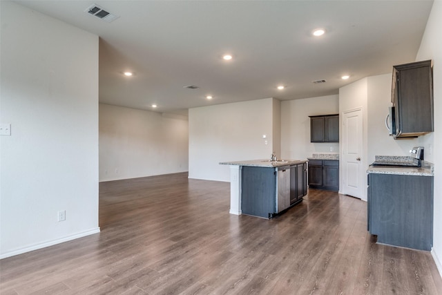 1653 Seadrift Dr, Forney, TX 75126 - kitchen featuring open floor plan, a center island with sink, dark wood finished floors, recessed lighting, and stainless steel microwave