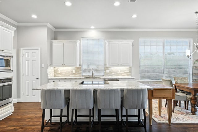 8161 Watson Rd, Lantana, TX 76226 - kitchen featuring stainless steel appliances, crown molding, a breakfast bar, backsplash, and recessed lighting