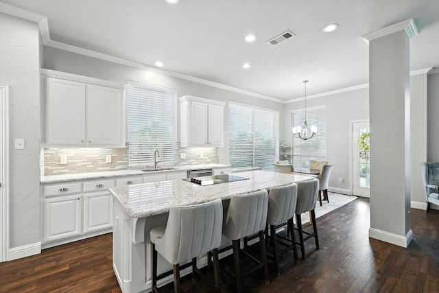 8161 Watson Rd, Lantana, TX 76226 - kitchen featuring a breakfast bar area, ornamental molding, decorative backsplash, white cabinets, and dark wood finished floors