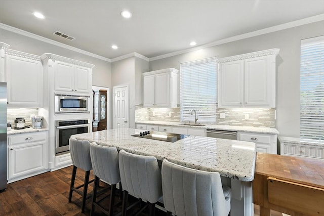 8161 Watson Rd, Lantana, TX 76226 - kitchen featuring stainless steel appliances, tasteful backsplash, a breakfast bar, white cabinetry, and recessed lighting