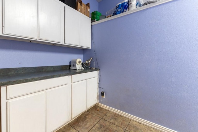 1211 Circle Ln, Bedford, TX 76022 - laundry area with dark tile patterned floors and baseboards