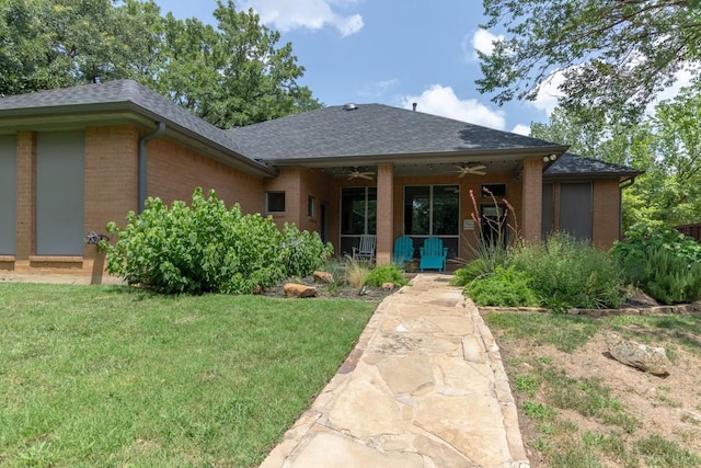 1211 Circle Ln, Bedford, TX 76022 - view of front facade with ceiling fan, brick siding, a front yard, and roof with shingles