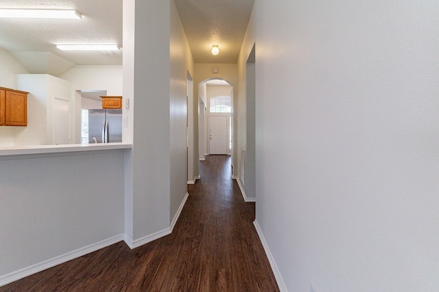 6736 Braeview Dr, Fort Worth, TX 76137 - hall featuring arched walkways, dark wood finished floors, healthy amount of natural light, and a textured ceiling