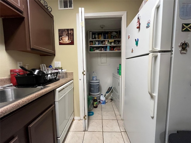 18333 Roehampton Dr Unit 513, Dallas, TX 75252 - kitchen featuring white appliances, light tile patterned floors, dark brown cabinets, and light countertops