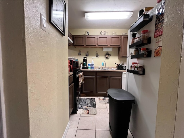 18333 Roehampton Dr Unit 513, Dallas, TX 75252 - kitchen with light tile patterned floors, black microwave, open shelves, light countertops, and electric range oven