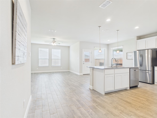 1016 Croxley Way, Fort Worth, TX 76247 - kitchen with stainless steel appliances, light wood finished floors, white cabinetry, an island with sink, and recessed lighting