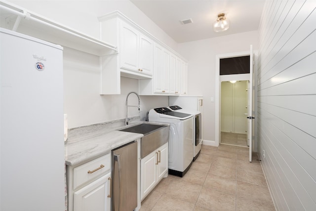 1861 Sand Creek Dr, Prosper, TX 75078 - laundry area featuring cabinet space, washer and clothes dryer, wood walls, and light tile patterned floors