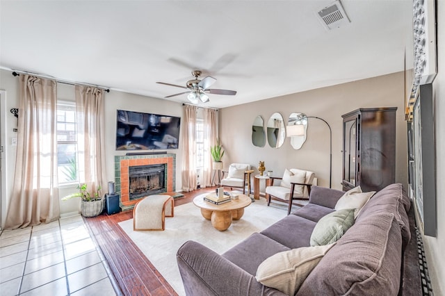 1161 Dallas Dr, Denton, TX 76205 - tiled living room with healthy amount of natural light, a fireplace with raised hearth, and ceiling fan
